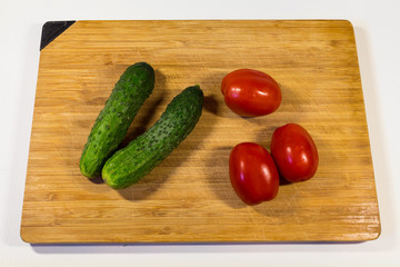 Vegetables cucumbers tomatoes on a wooden board