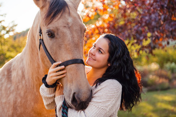 A Woman with her horse at sunset, autumn outdoors scene