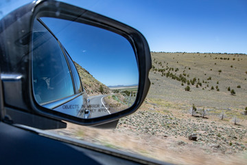 Fototapeta premium Asphalt road in car side mirror