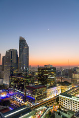 Naklejka premium Landscape with sunset over the building and blue sky at Bangkok ,Thailand. View of the tall building in capital with twilight.