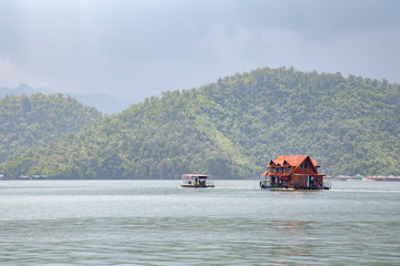 Landscape of the mountain and The ship is on the river with blue sky in the morning. View of the mountain with blue sky at Srinakarin Dam , Kanchanaburi province , Thailand.