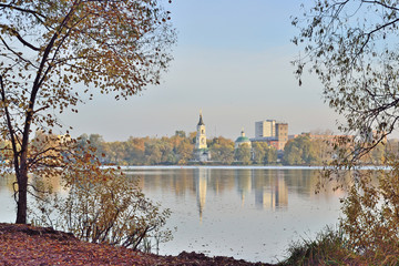 Obraz premium the old church and other buildings stand on the opposite bank of the lake on an autumn day