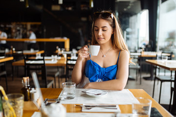Stunning woman enjoying her coffee in restaurant