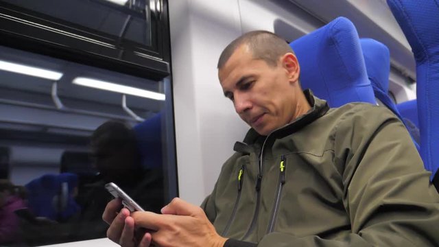 traveler unknown middle-aged man smartphone in the subway writes sms to social media messenger. slow motion video. man metro in railway train. man traveler in train concept travel lifestyle