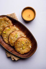 Malpua sweet - Traditional Indian dessert or pancake for festivals, served in plate with rabri/rabdi . selective focus