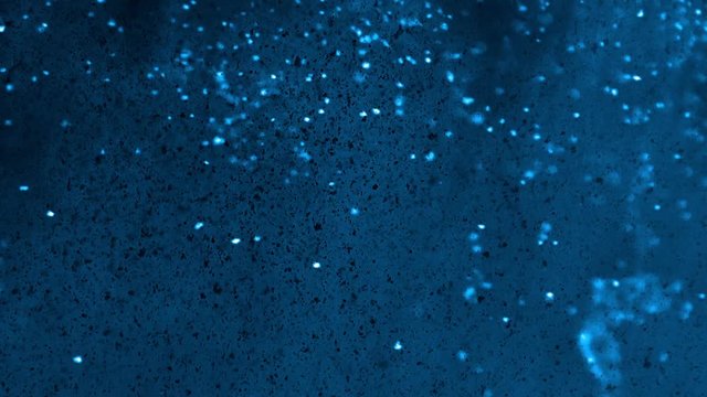 Blue, bright and dark particles floating on a dark nebulous blue background - full hd