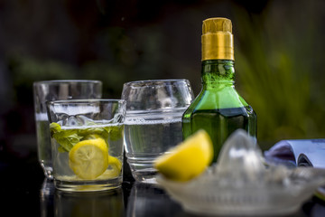 Mojito drink in a transparent glass on wooden surface with white rum,soda,lemon juice,fresh mint leaves,ice cubes and sugar,Close up shot or top shot.