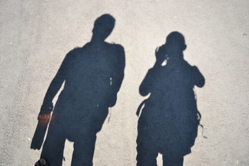 Shadows of young man and woman on the asphalt