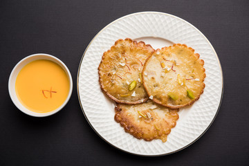 Malpua sweet - Traditional Indian dessert or pancake for festivals, served in plate with rabri/rabdi . selective focus