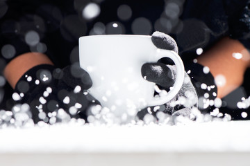 Cup of hot coffee in the hands in a cold day