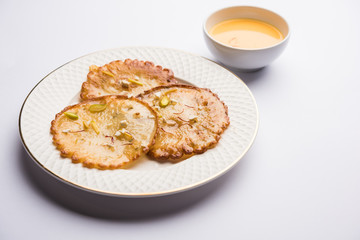 Malpua sweet - Traditional Indian dessert or pancake for festivals, served in plate with rabri/rabdi . selective focus