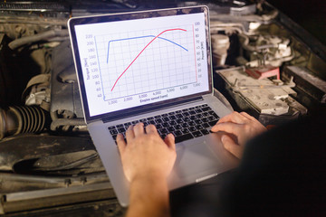 Closeup hands of mechanic with the help of diagnostic machines is ready for use with the car....