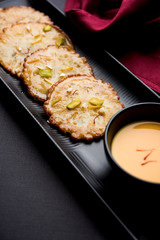 Malpua sweet - Traditional Indian dessert or pancake for festivals, served in plate with rabri/rabdi . selective focus