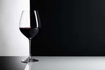 Cercles muraux Vin Verre de vin rouge sur fond réfléchissant.