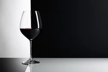 Papier Peint photo Vin Verre de vin rouge sur fond réfléchissant.