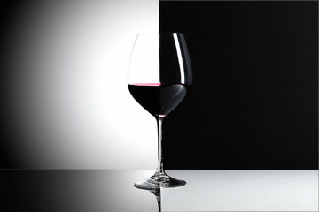 Glass of red wine on a reflexive background.