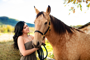 Obraz premium A Portrait of young beautiful woman with brown horse outdoors