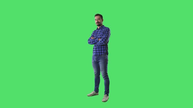 Confident successful happy young casual bearded man standing and crossing arms. Full body isolated on green screen background. 