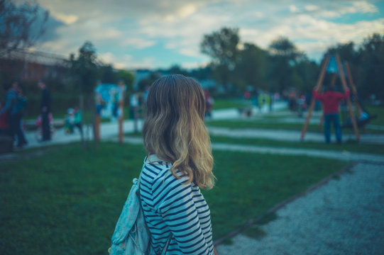 Young woman standing in playground at sunset