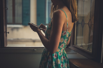 Obraz premium Young woman using smart phone at home