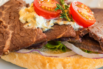 Baked ham sandwich with vegetables close up