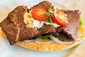 Baked ham sandwich with vegetables close up