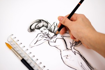 Close-up of an illustrator  hand drawing a fashion sketch