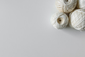 Top view on skein of cotton yarns for handicraft in beige color, on white background with copy space.