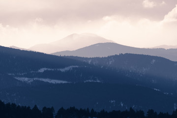 Dramatic winter storm blows over a cold barren landscape at sunset