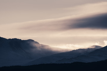 Dramatic winter storm blows over a cold barren landscape at sunset