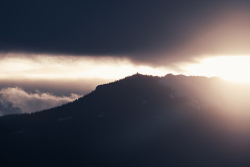 Dramatic winter storm blows over a cold barren landscape at sunset