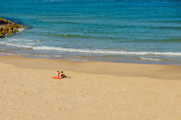 Fototapeta na wymiar Young couple resting on the beach.