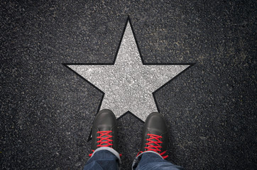 Sneakers on asphalt road with white star
