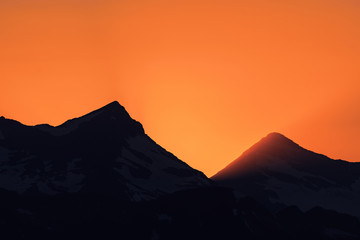 Dramatic sun rays as the sun sets behind Heaven's Peak and Livingston Range, in Glacier National Park, Montana