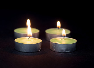 Group of burning candles on black background