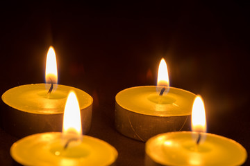 Group of burning candles on black background