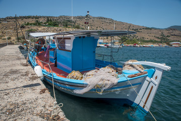 Greek fishing boat tied up at a cement pier