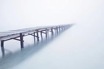 Foto auf Acrylglas Küste Foodbridge in the fog with a man standing on it