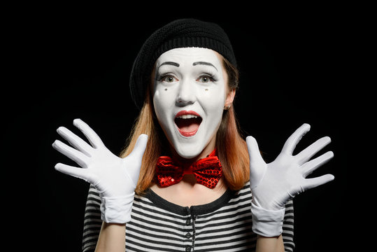 Happy female mime on black