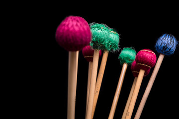 Colorful percussion mallets on a black background