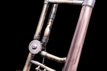 A part of a vintage looking trombone on a black background