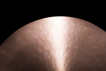 A brass cymbal on a black background