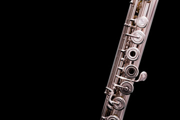 A silver plated flute on a black background