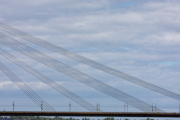A part of a bridge with wires on a cloudy background