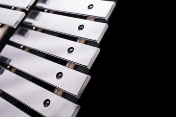 A part of a metal xylophone on a black background
