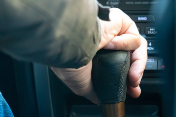 close up driver hand holding car manual trasmission stick f