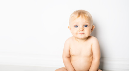 A six month old baby, sit on the floor