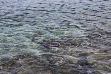 A sea water and stones at a seabed seen through it