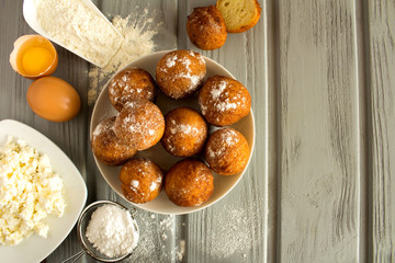 Homemade cottage cheese donuts and ingredients on the grey  wooden background.Top view.Copy space.