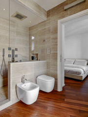 modern bathroom interiors overlooking on the bedroor, in the foreground the bidet and toilet bowl,...